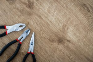 trois pinces à manche noir sur une surface marron