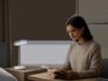 Une mise en scène premium montre une lumière bleue réglable intégrée à un intérieur moderne, entre réveil, lecture et travail. L’image évoque une approche technique, sobre et rassurante de l’éclairage quotidien.