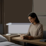 Une mise en scène premium montre une lumière bleue réglable intégrée à un intérieur moderne, entre réveil, lecture et travail. L’image évoque une approche technique, sobre et rassurante de l’éclairage quotidien.