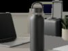 Une bouteille isotherme premium mise en scène dans un univers quotidien, entre bureau et déplacement. L’image évoque le confort, la praticité et l’hydratation durable.