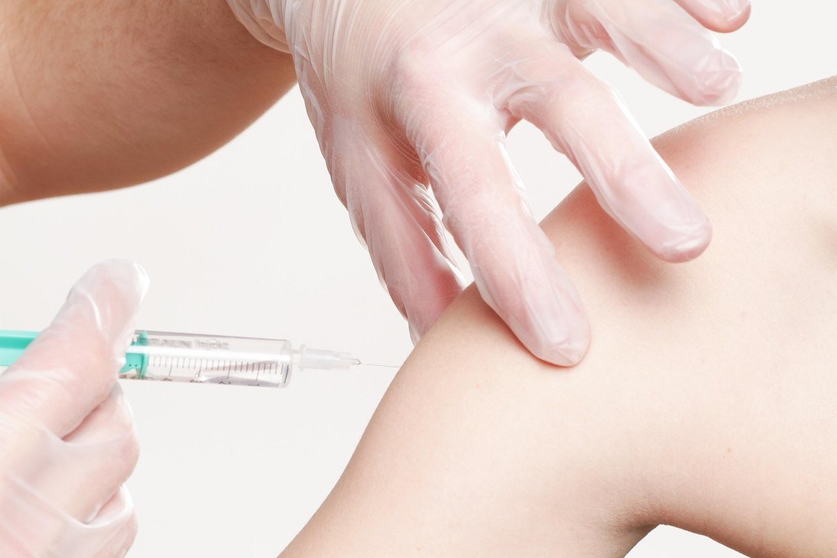 Une injection est administrée dans le bras d'une personne par un professionnel médical