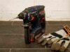 Perceuse et gants de travail sur un sol en carrelage