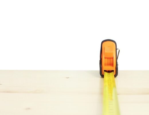 Ruban à mesurer jaune déployé horizontalement sur une surface de bois clair